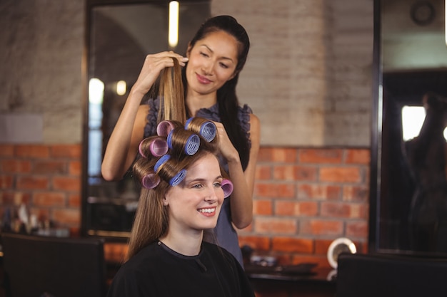 Weiblicher Friseur, der Kundenhaar stylt