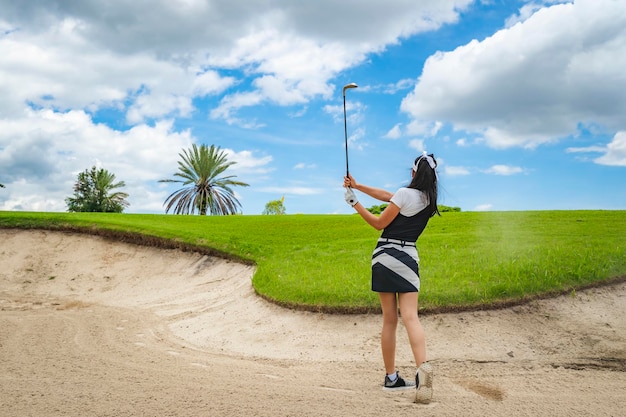 Weiblicher Golfspieler, der Golf im professionellen Golfplatz spielt