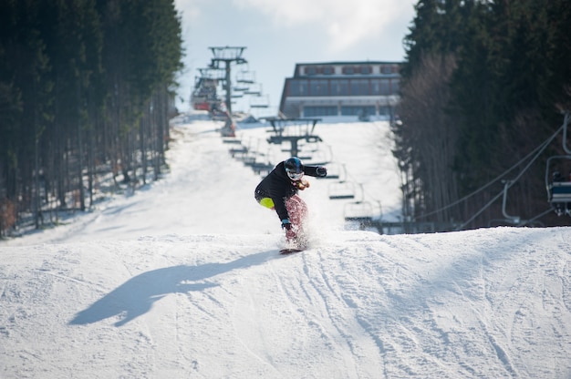 Weiblicher Internatsschüler auf dem Snowboard, nachdem über die Steigung gesprungen worden ist