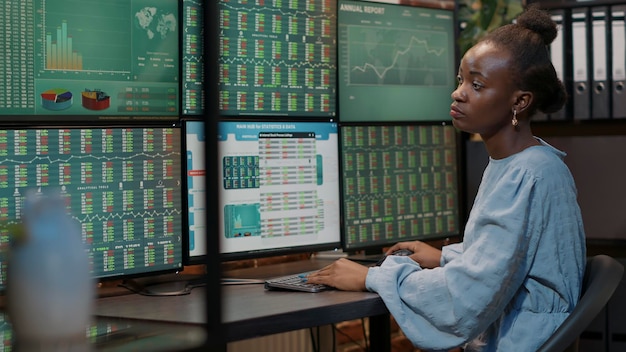 Weiblicher Investor, der den Devisenmarkt auf mehreren Monitoren analysiert, um an Aktienhandelsverkäufen zu arbeiten. Hedgefonds-Statistik mit Kapitalpreis und Geldanlage, Bankgewinn.