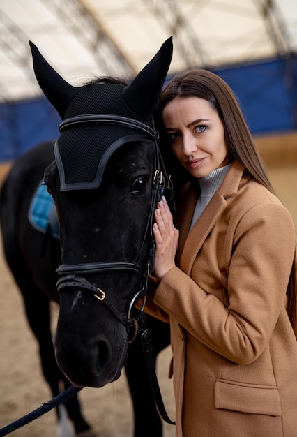 Weiblicher Jockey mit Pferdeporträt Junge schöne Dame mit Pferd