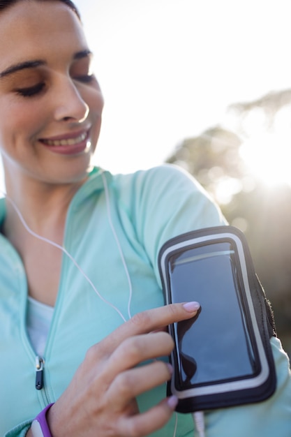 Weiblicher Jogger, der Musik auf Handy hört