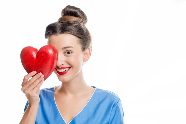 Weiblicher Kardiologe in der Uniform, die rotes Herz lokalisiert auf dem weißen Hintergrund hält