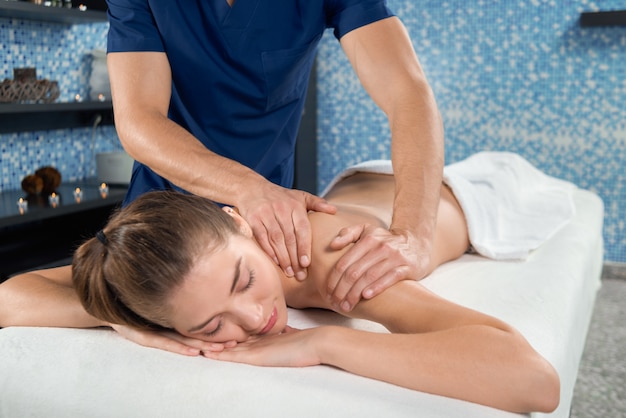 Weiblicher Kunde im Badekurortsalon, der entspannende Massage erhält