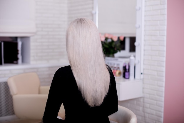Weiblicher Rücken mit langen glatten blonden Haaren
