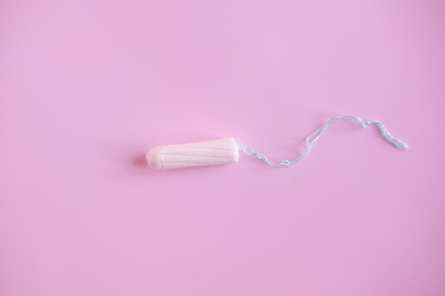 Weiblicher Tampon auf rosa Hintergrund Hygienischer weißer Tampon für Frauen