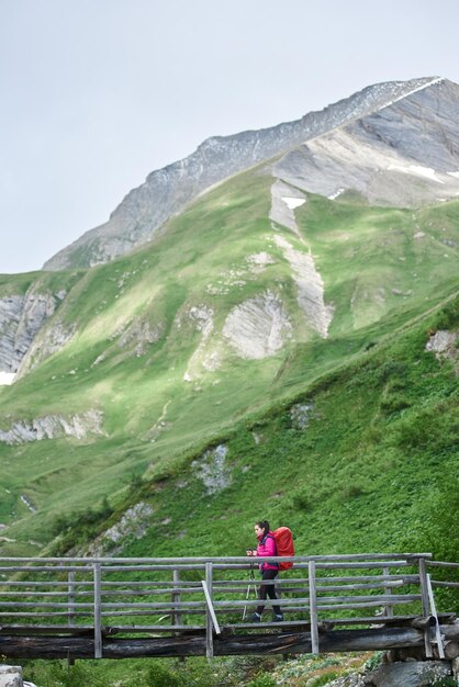 Foto weiblicher wanderer, der die brücke in den bergen überquert