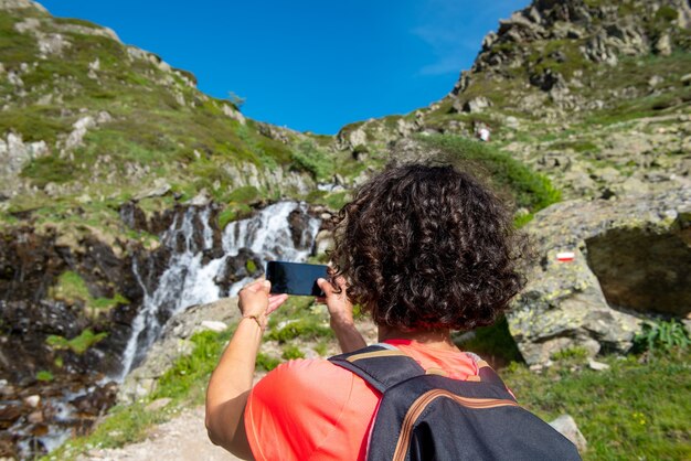 Weiblicher Wanderer nahe wildem Spritzwasserfall