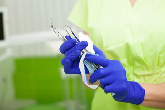 Weiblicher Zahnarzt nehmen die zahnmedizinischen Werkzeuge, die in einer Schutzfolie verpackt werden