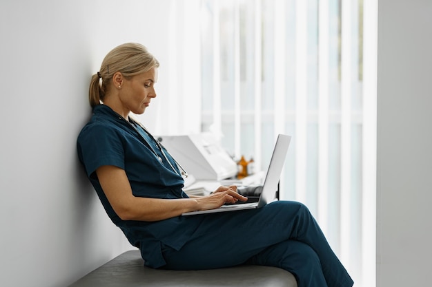 Weibliches medizinisches Personal, das Laptop verwendet, während es im Büro von doctor39s arbeitet