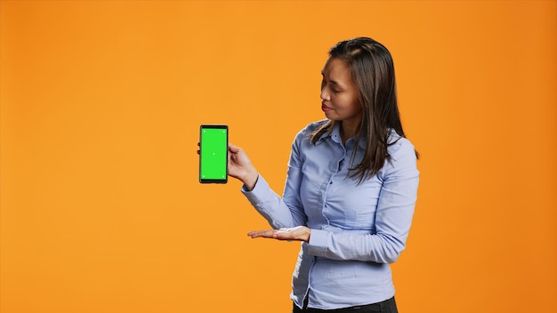 Weibliches Model präsentiert einen grünen Bildschirm auf dem Telefon-Layout