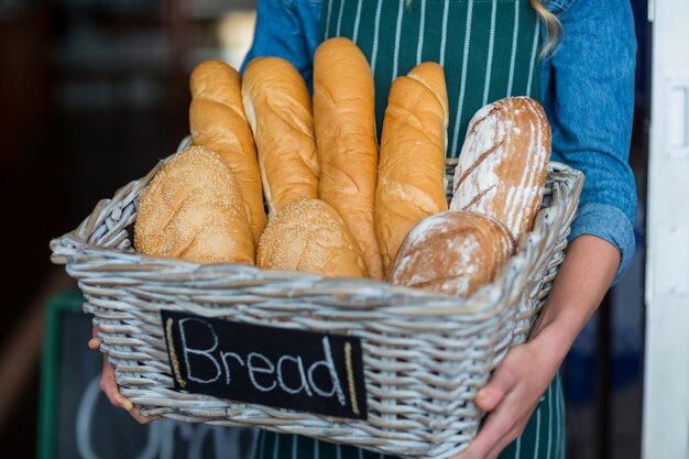 Weibliches Personal, das einen Brotkorb hält