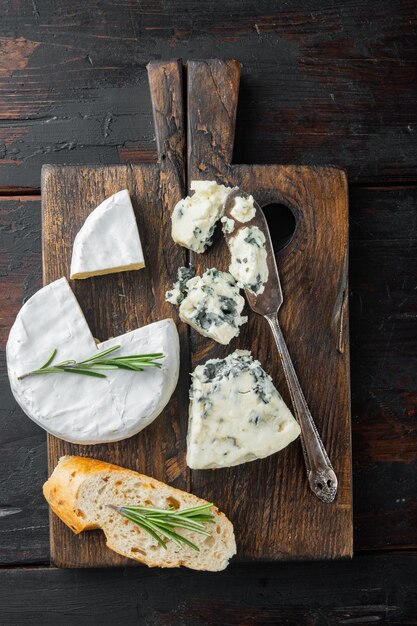 Weiche Blauschimmelkäsekeile auf dunklem Holz, flach liegend