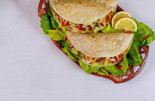 Weiche Mehl Tortillas gefüllt mit Salat, Fleisch und Gemüse auf weißem Hintergrund.