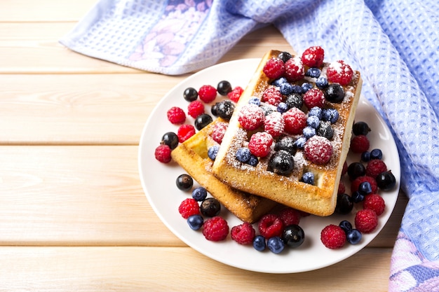 Weiche Waffel mit Blaubeere und Himbeere auf blauer Leinenserviette