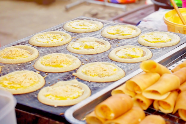 Weiche Waffel mit Sahne oder Rollenpfannkuchen gefüllt mit Sahne auf dem Ofen. Thailändischer Nachtisch im Markt.