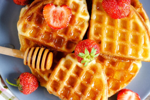 Weiche Waffeln Erdbeeren und mit Honig gegossen