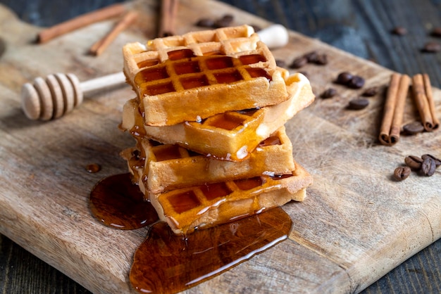 Weiche Waffeln mit natürlichem Bienenhonig auf einem Servierbrett