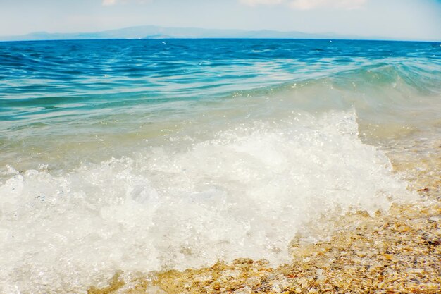 Weiche Welle des blauen Ozeans auf sandigem Strandhintergrund