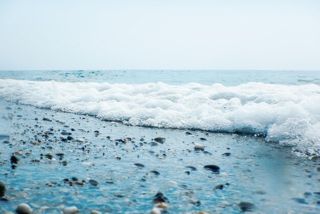 Weiche Welle des blauen Ozeans auf sandigem Strandhintergrund