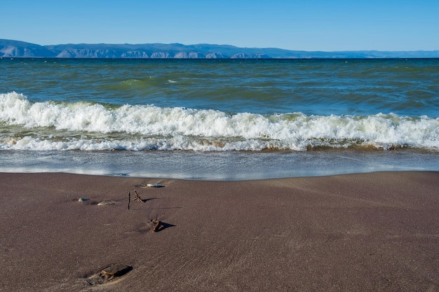 Weiche Welle des roten Sandstrandes des Baikalsees. Hintergrund. Selektiver Fokus.