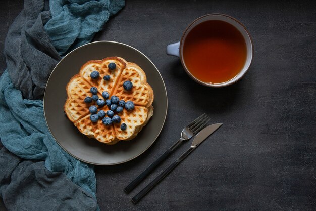 Weiche wiener waffeln mit blaubeeren und einer tasse tee