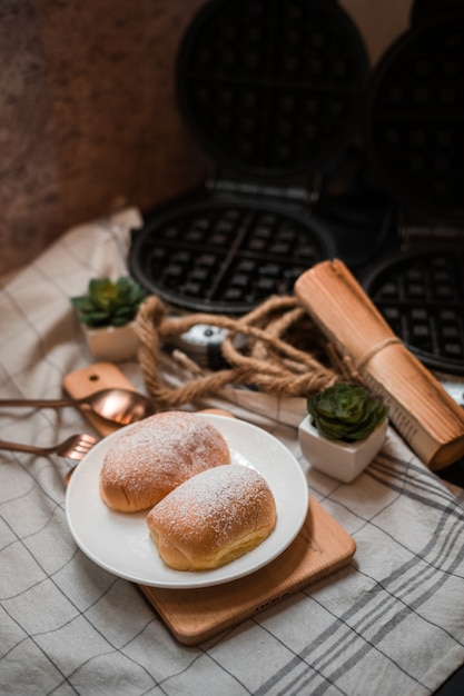 Weiches Butterbrötchen mit Puderzucker auf einem Holzteller