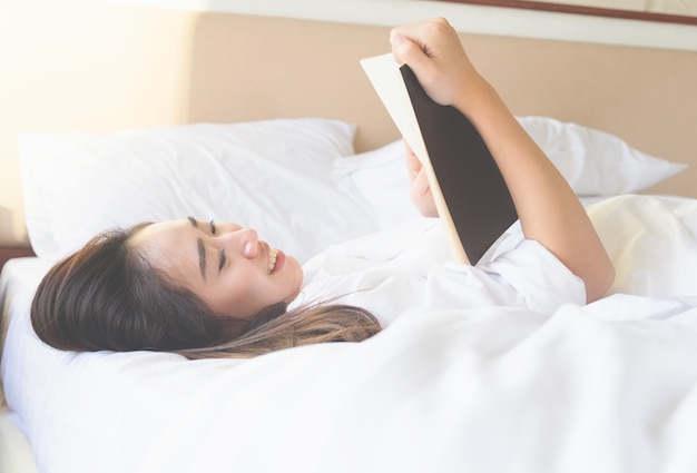 Weiches Foto der Frau entspannen sich und lesen auf dem Bett mit altem Buch.