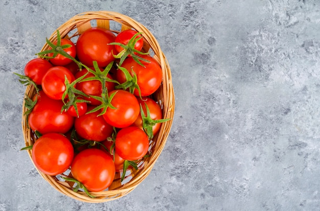 Weidenschüssel mit roten Tomaten. Studio-Foto
