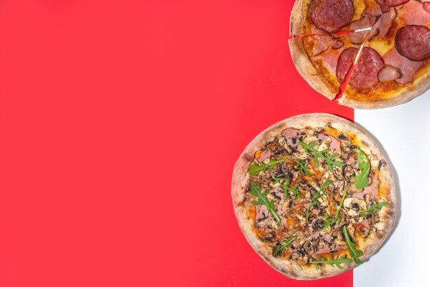 Weihnachten dekorierter Hintergrund mit Peperoni- und Pilzpizza, Lieferung und Restaurant Xmas Mittags- und Partymenü, der Weihnachtsmann liefert Pizza zu Weihnachten, weiß-roter, moderner, hochfarbiger Hintergrund