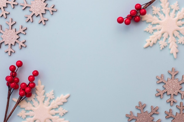 Weihnachten flatlay Schneeflocken und Fichtenzweig auf blauem Hintergrund