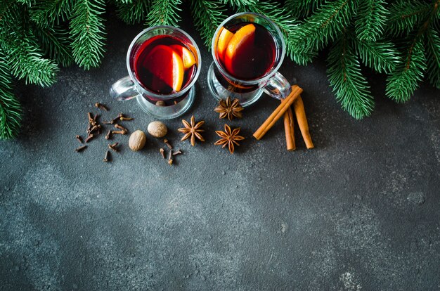 Weihnachten glühte Rotwein mit Gewürzen auf dunklem Beton