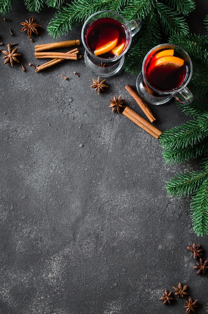 Weihnachten glühte Rotwein mit Gewürzen auf dunklem Hintergrund