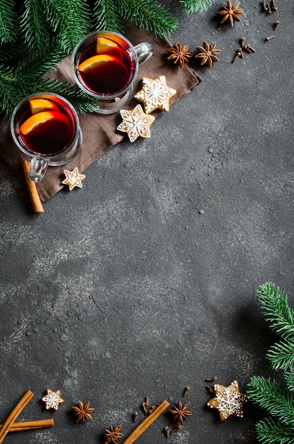 Weihnachten glühte Rotwein mit Gewürzen auf dunklem konkretem Hintergrund