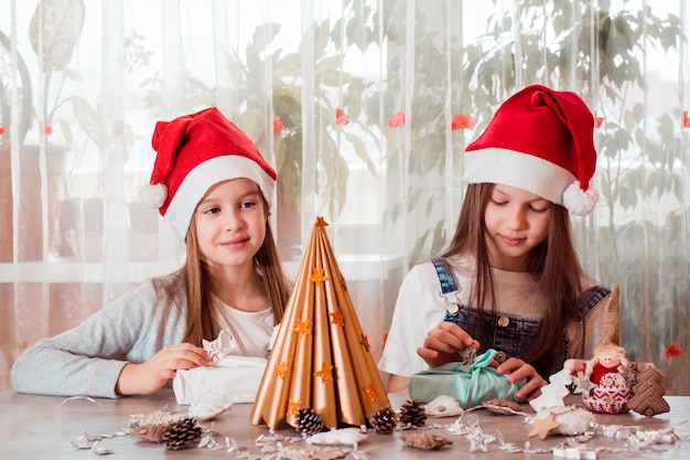 Weihnachten handgemacht. Mädchen bereiten Öko-Geschenke Furoshiki vor. Kein Verlust