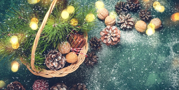 Weihnachten Hintergrund. Korb mit Tannenzapfen und Zweigen, Nüssen und Zimt. Bannerformat
