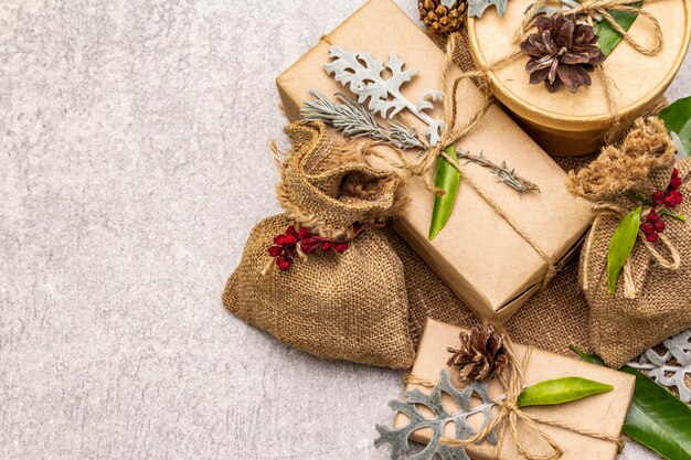 Weihnachten null Abfallkonzept. Neujahr umweltfreundliche Verpackung. Festliche Schachteln aus Kraftpapier und Säcken mit verschiedenen organischen Verzierungen