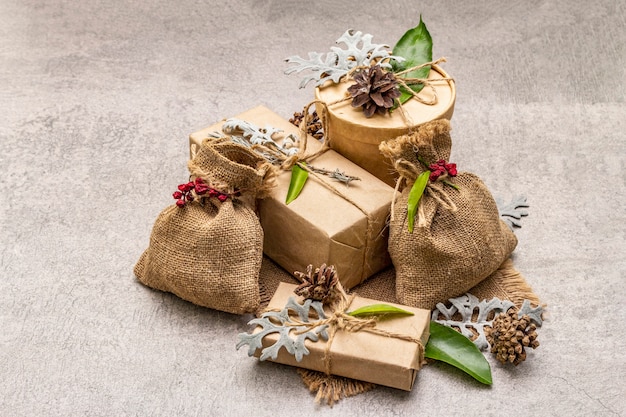 Weihnachten null Abfallkonzept. Neujahr umweltfreundliche Verpackung. Festliche Schachteln aus Kraftpapier und Säcken mit verschiedenen organischen Verzierungen