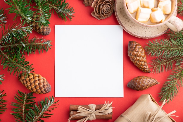 Weihnachten oder Komposition, Vorlage. Dekorationen, Schachtel, Zimt, Zapfen, Tannen- und Fichtenzweige, Tasse Kaffee auf rotem Papier. Draufsicht.