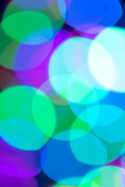 Weihnachten oder Neujahr defokussierten festlichen Bokeh-Hintergrund in der trendigen lila-blau-grünen Farbnahaufnahme. Vertikale Ausrichtung.