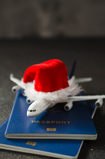 Weihnachten oder Neujahr Reisekonzept. Spielzeugflugzeug mit Pässen und Santa Claus-Hut.