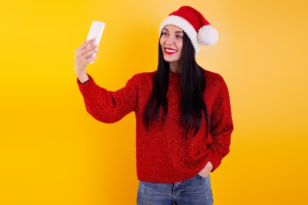 Weihnachten online Glückwunsch. Frau in der Weihnachtsmütze mit mobilem Tablet für Videoanruffreunde und Eltern.