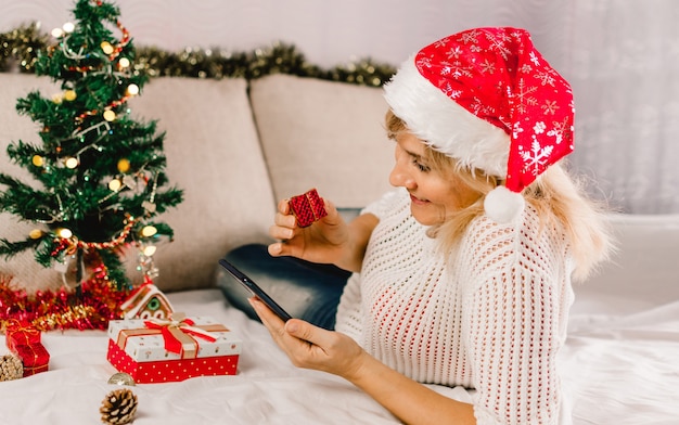 Weihnachten Online-Shopping. Käuferin bestellt auf dem Handy