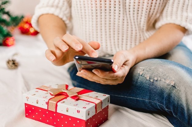 Weihnachten Online-Shopping. Käuferin bestellt auf dem Handy.