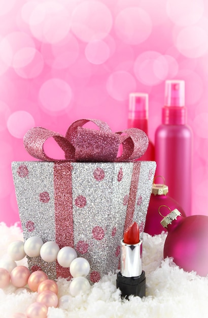 Weihnachten präsentiert Schönheitsprodukte mit Schnee und rosa Hintergrund