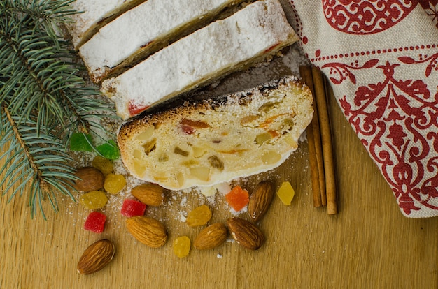 Weihnachten stollen auf darkfestive Hintergrund mit den Tannenzweigen, den Lichtern und den Beeren