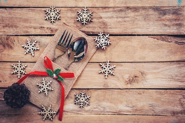 Weihnachten Tisch Platz Einstellung und Besteck, Schneeflocken, Tannenzapfen auf Holzuntergrund mit Platz.