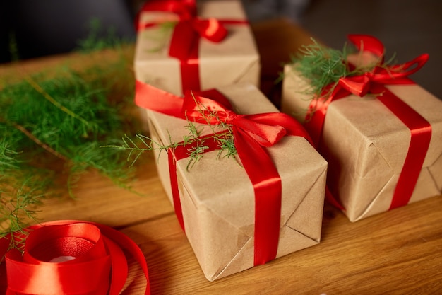 Weihnachten umweltfreundliche Verpackung aus Kraftpapier und Tannenzweigen Geschenke für die Weihnachtszeit, Weihnachten auf Holztisch, Öko-Dekor, Weihnachtsgeschenk-Geschenkbox