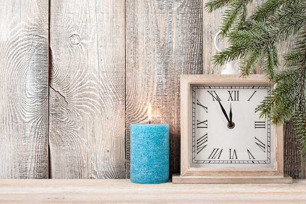 Weihnachten und Silvester Hintergrund mit blauer Kerze und Uhr