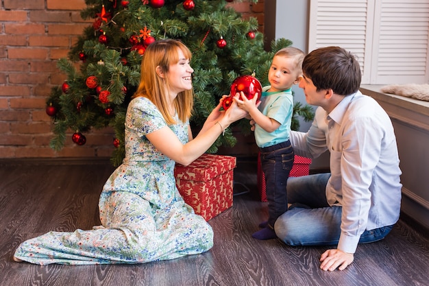 Weihnachten, Weihnachten, Familie, Menschen, Glückskonzept - glückliche Eltern, die mit niedlichem Baby spielen